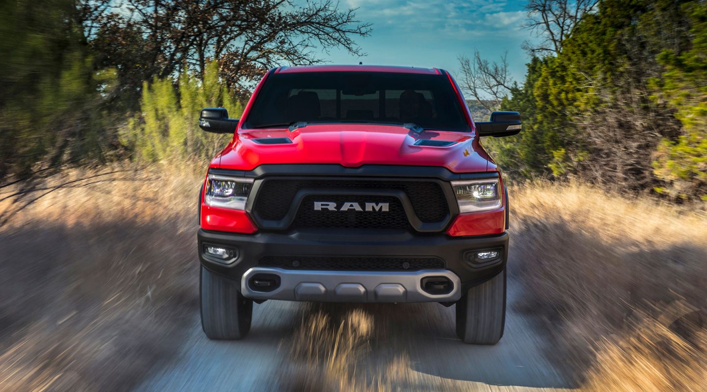 Two 2020 Ram 1500 models parked in the driveway of a farm.