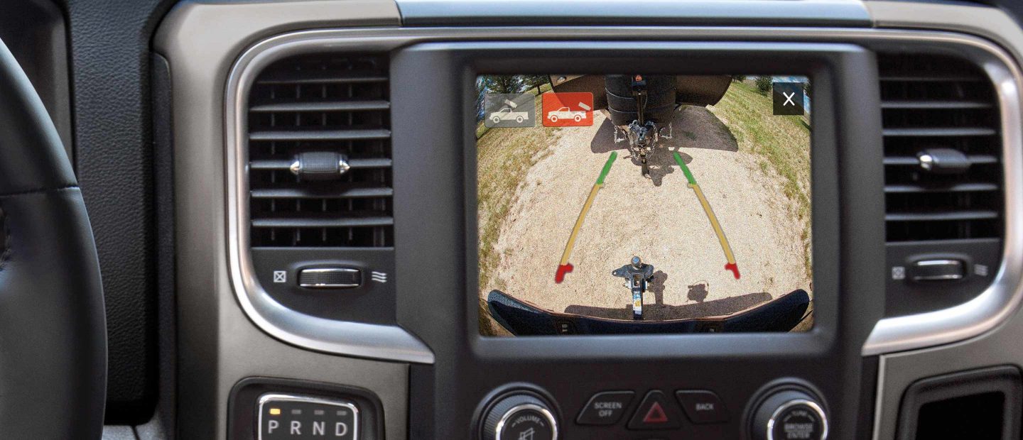 The Uconnect touchscreen in the 2022 Ram 1500 Classic with the hitch view camera selected, showing the trailer hitch as the truck backs up to a trailer.
